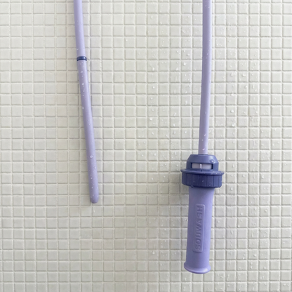 Purple Squwash silicone hose with a nozzle on a tiled bathroom wall