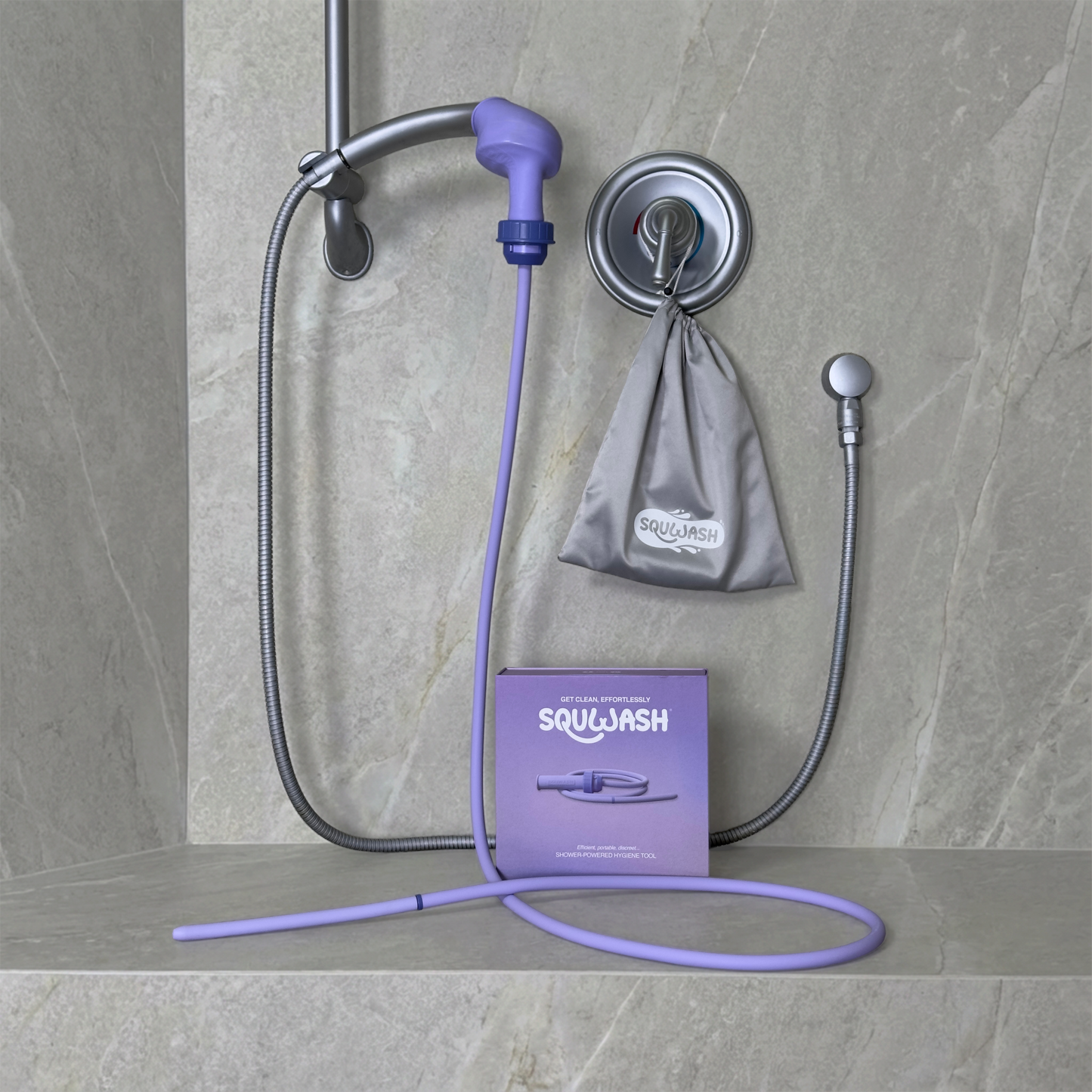 Portable shower douche and enema kit attached to shower head displayed with box and travel bag in modern bathroom setting