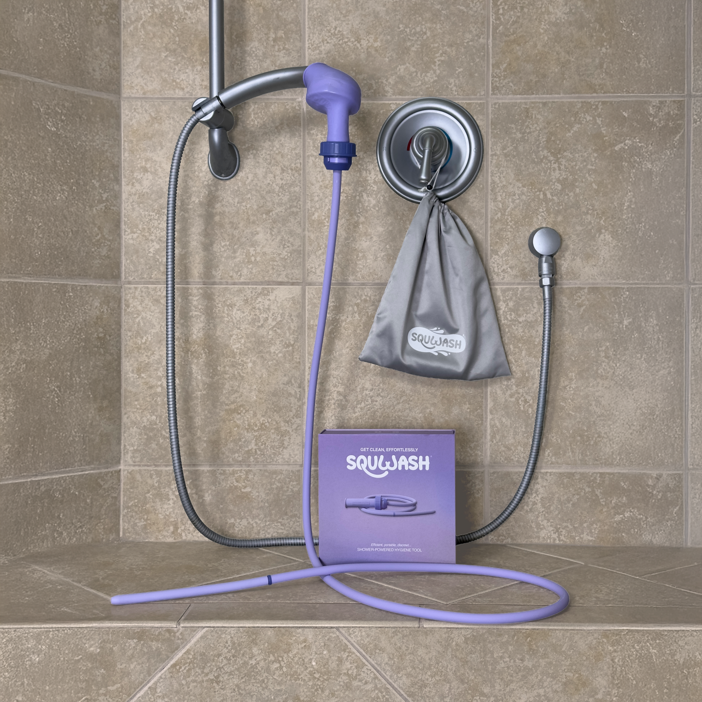 Patented portable shower douche and enema attached to shower head with packaging on a tiled bathroom bench, featuring the brand 'Squwash'.