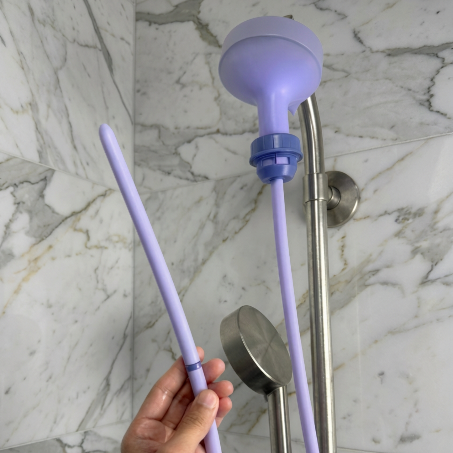 Purple Squwash shower douche attached to shower head with silicone tip held in hand
